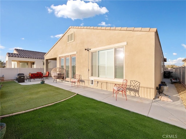 back of property featuring a yard, a patio area, a fenced backyard, and stucco siding