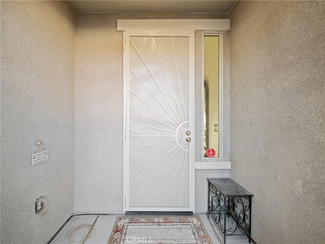 view of exterior entry with stucco siding