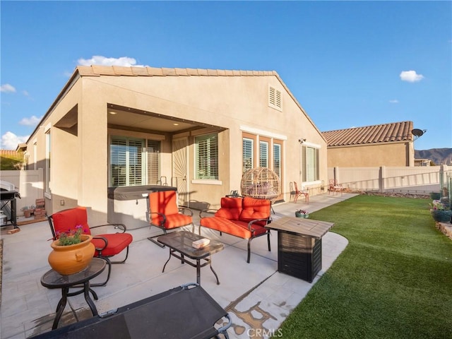 back of property with a patio, a yard, stucco siding, a fenced backyard, and an outdoor living space