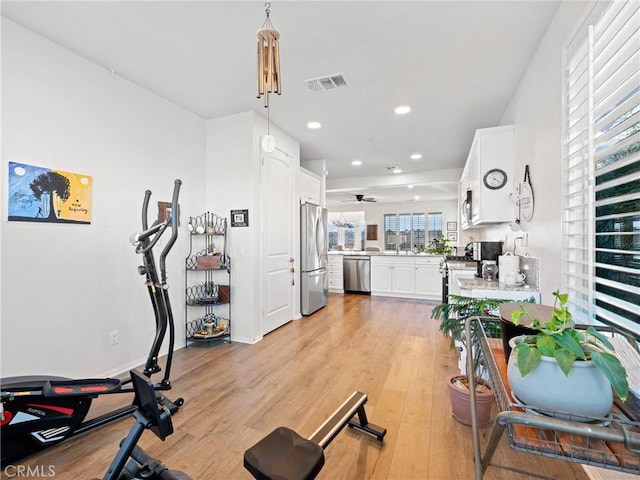 workout room featuring recessed lighting, a sink, visible vents, and light wood-style floors