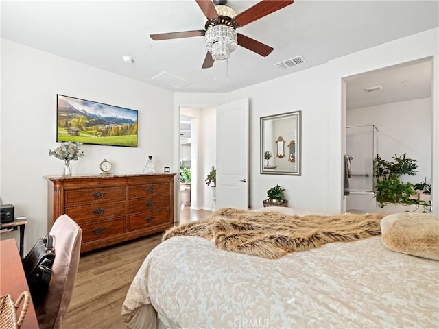 bedroom with light wood-style floors, visible vents, and ceiling fan