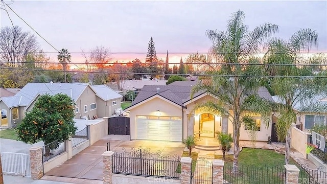 view of front of property with concrete driveway, a fenced front yard, and a gate