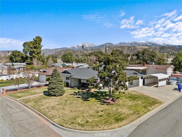 view of front of property featuring a mountain view, a garage, concrete driveway, a residential view, and a front yard