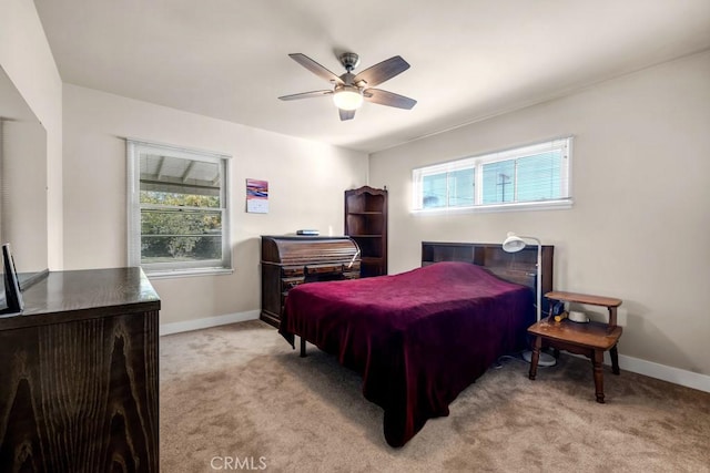 bedroom with light carpet, multiple windows, and baseboards