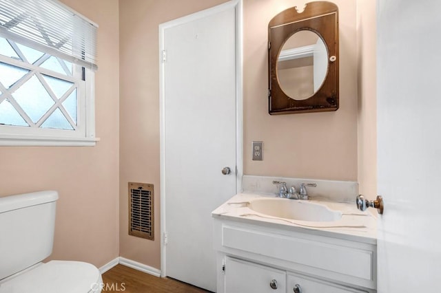 bathroom featuring baseboards, visible vents, vanity, and toilet