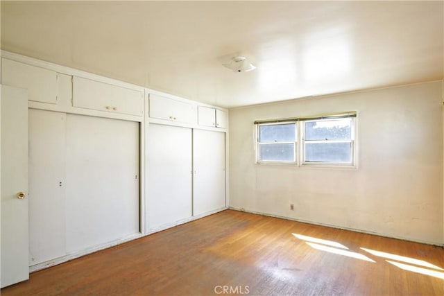 unfurnished bedroom with a closet and wood finished floors