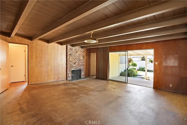 unfurnished living room with wooden ceiling, wooden walls, a fireplace, and beamed ceiling