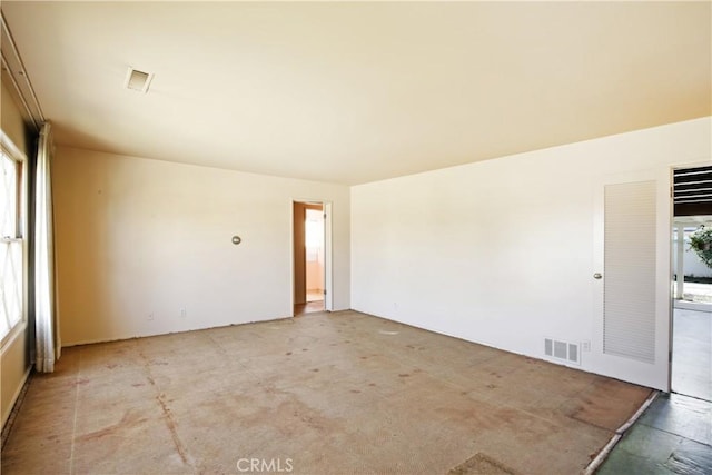 empty room with a wealth of natural light and visible vents