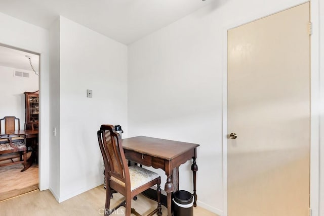 home office featuring light wood-style flooring, visible vents, and baseboards