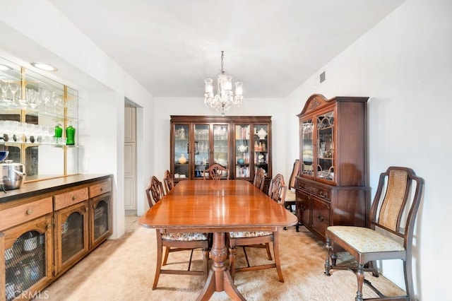 dining space with light carpet, a notable chandelier, and visible vents