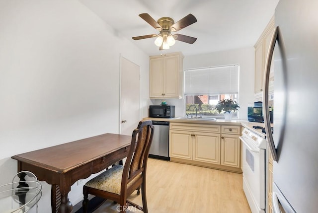 kitchen featuring light wood-style flooring, cream cabinets, a sink, and stainless steel appliances