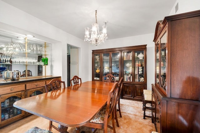 dining area with visible vents, a chandelier, and bar area