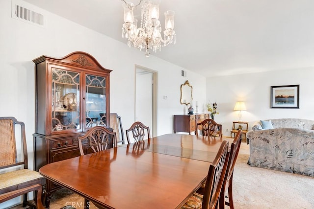 dining space with visible vents, a notable chandelier, and carpet floors