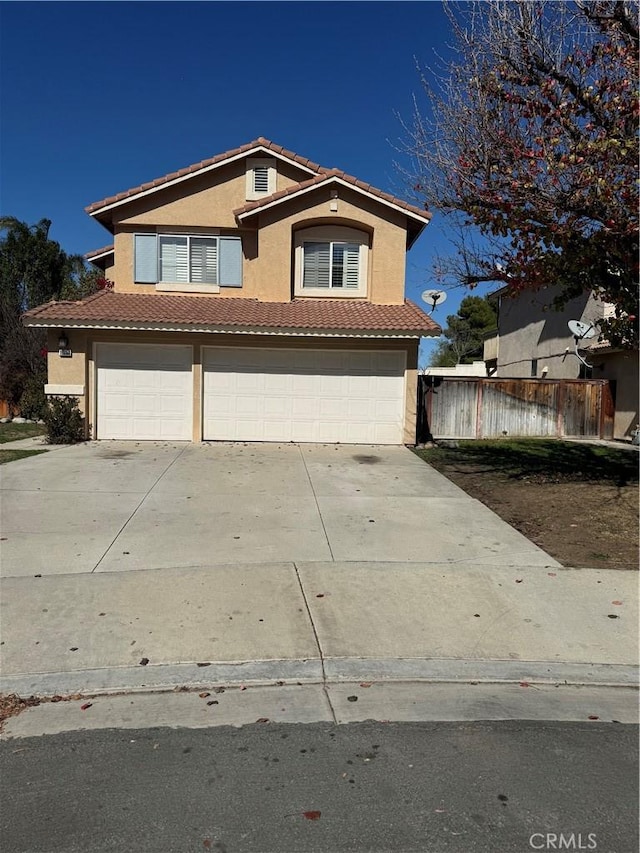 view of front of property with stucco siding, concrete driveway, an attached garage, fence, and a tiled roof