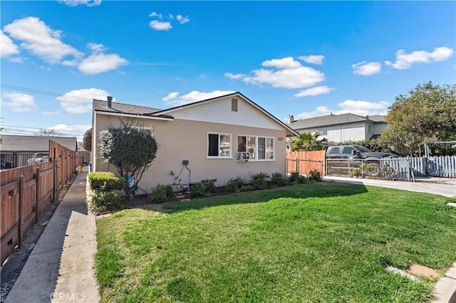 view of front facade with a front lawn, cooling unit, fence, and stucco siding