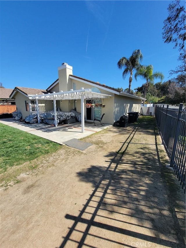 rear view of property with a patio, fence, a pergola, and stucco siding