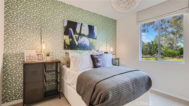 carpeted bedroom with an accent wall, multiple windows, baseboards, and wallpapered walls