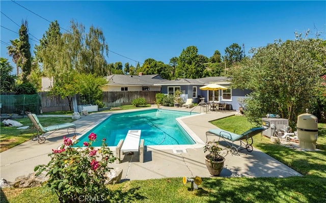 view of pool with a fenced in pool, a patio, a lawn, a fenced backyard, and a diving board