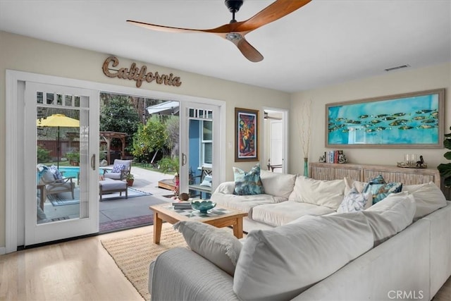 living room featuring visible vents, ceiling fan, and wood finished floors