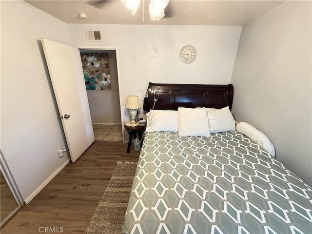 bedroom featuring wood finished floors, visible vents, and baseboards