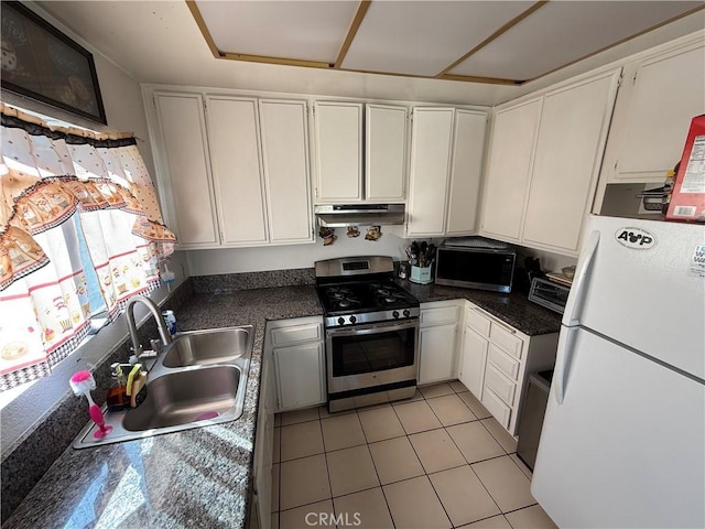 kitchen with stainless steel appliances, a sink, white cabinets, and under cabinet range hood