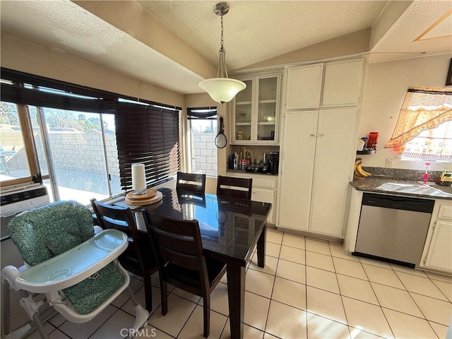 dining area with cooling unit, vaulted ceiling, a textured ceiling, and light tile patterned floors