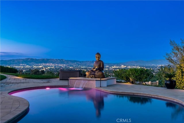 outdoor pool with a patio area and a mountain view