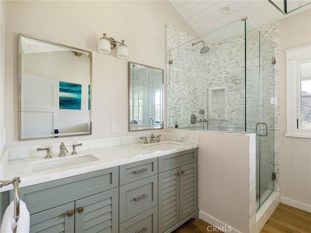 full bath featuring vaulted ceiling, double vanity, a stall shower, and a sink