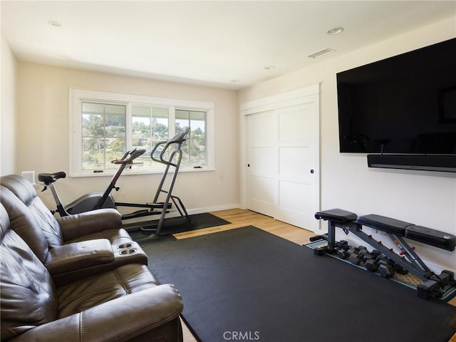 exercise area with light wood-type flooring, visible vents, baseboards, and recessed lighting