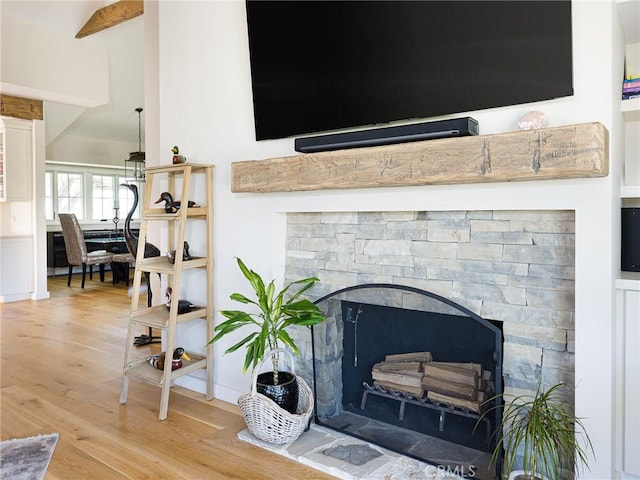 interior details with a fireplace with raised hearth and wood finished floors