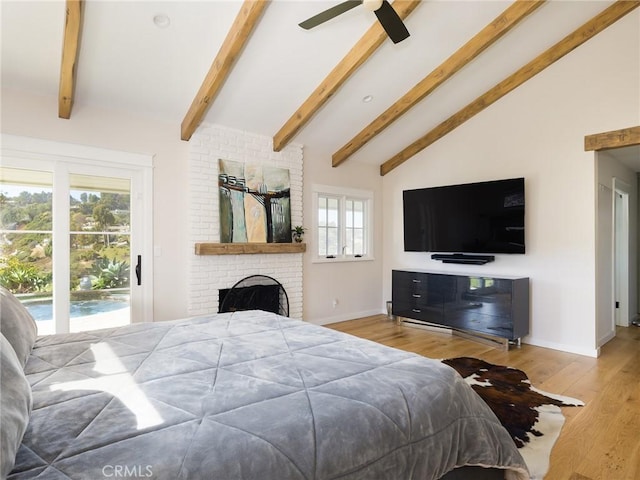 bedroom featuring lofted ceiling with beams, a fireplace, baseboards, access to exterior, and light wood finished floors