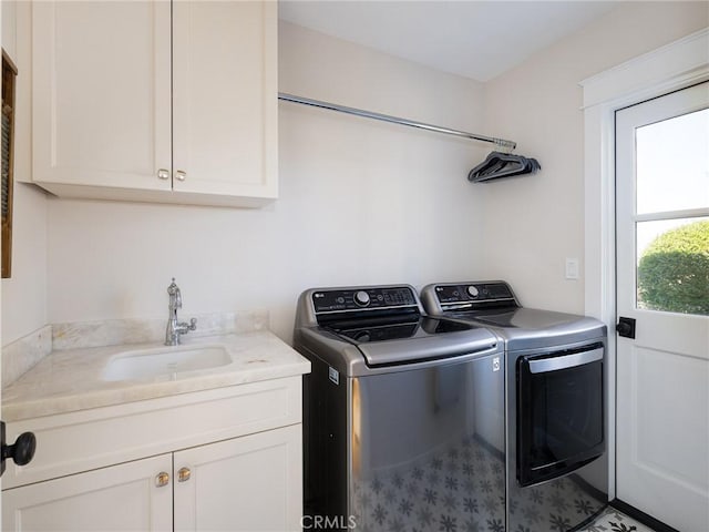 clothes washing area featuring washer and dryer, cabinet space, and a sink