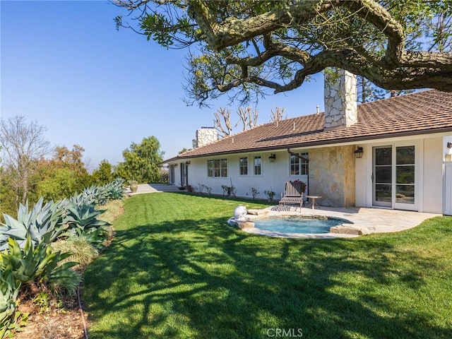 back of property with a lawn, a chimney, and a patio