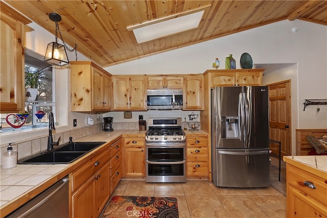 kitchen featuring tile countertops, wooden ceiling, a sink, hanging light fixtures, and appliances with stainless steel finishes