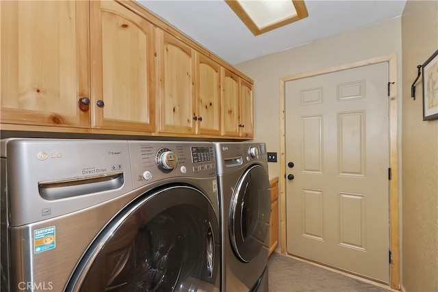 clothes washing area featuring cabinet space and independent washer and dryer