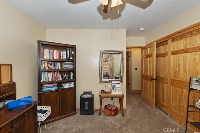 office space with a textured ceiling, carpet, a ceiling fan, and baseboards