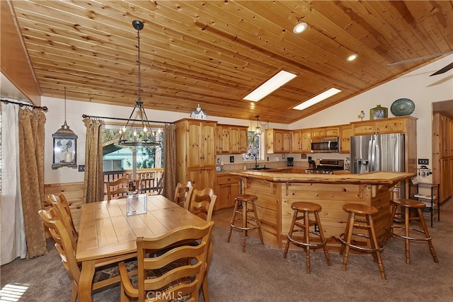 dining space with a wealth of natural light, a skylight, carpet flooring, and wood ceiling