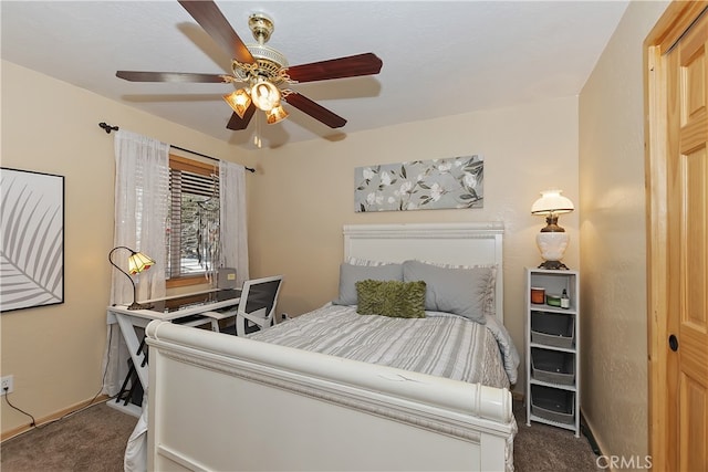 bedroom featuring ceiling fan and dark carpet