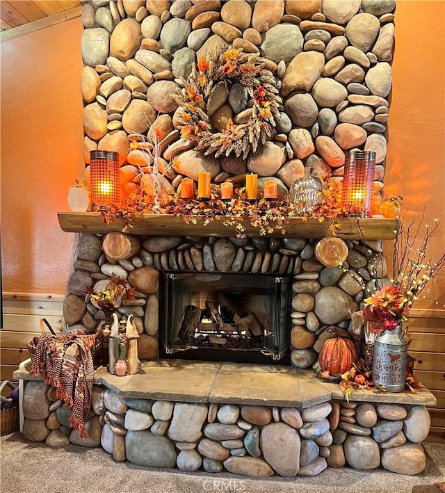 room details with carpet floors, a textured wall, and a fireplace