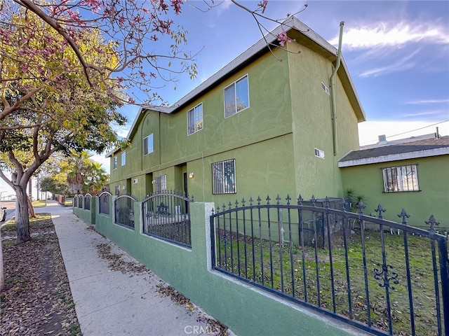 view of property exterior featuring a fenced front yard and stucco siding