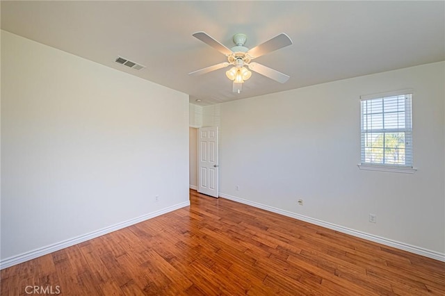 unfurnished room featuring baseboards, ceiling fan, visible vents, and light wood-style floors