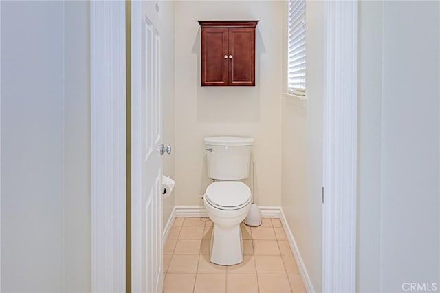 bathroom featuring toilet, baseboards, and tile patterned floors