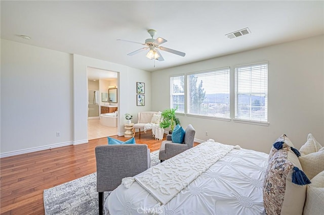 bedroom with connected bathroom, wood finished floors, a ceiling fan, visible vents, and baseboards