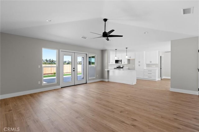 unfurnished living room with light wood-style flooring, a ceiling fan, visible vents, and baseboards