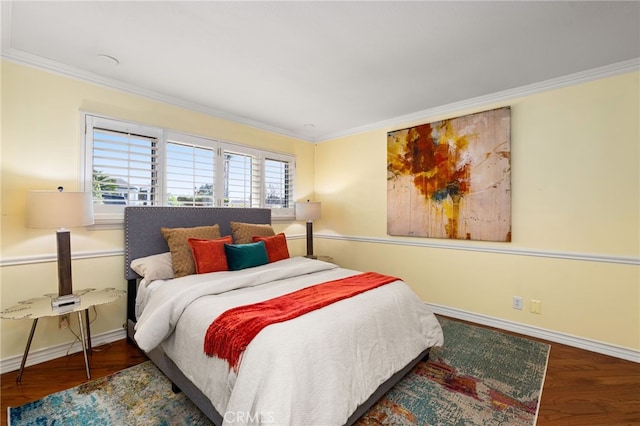 bedroom featuring baseboards, ornamental molding, and wood finished floors