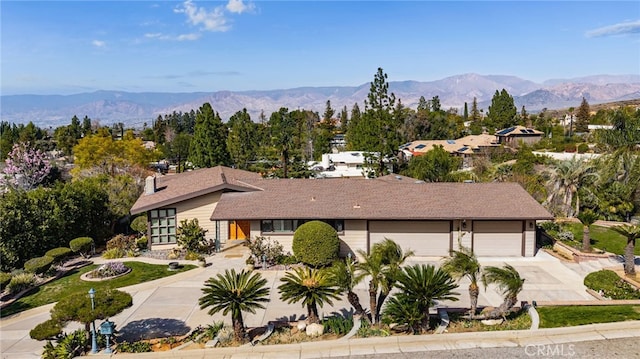 view of front of home featuring an attached garage, driveway, and a mountain view