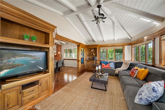 living area with a ceiling fan, wood-type flooring, lofted ceiling with beams, and baseboards