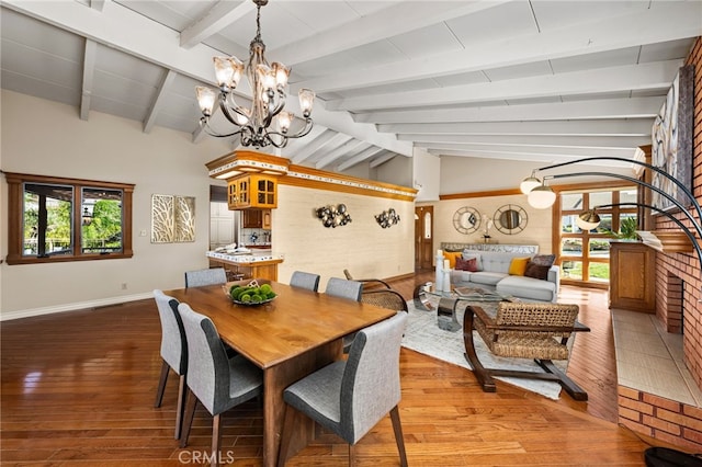 dining room with lofted ceiling with beams, wood finished floors, and a healthy amount of sunlight