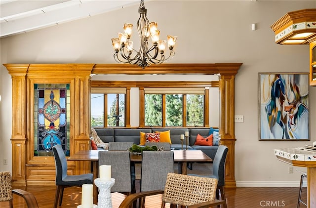 dining space with vaulted ceiling, a notable chandelier, wood finished floors, and baseboards