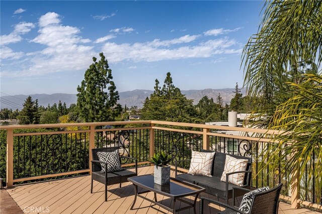 deck with outdoor lounge area and a mountain view